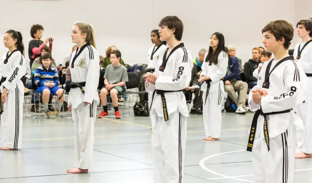 Conquer Your Taekwondo Black Belt Test Overcoming Nervousness And   Young Teenagers Taekwondo Black Belts On A Line Spectators On The Background 1024x602 